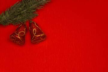 Christmas bells on fir isolated on red background