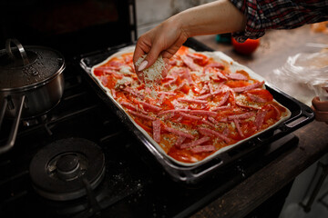 hands preparing pizza in the kitchen