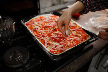 hands preparing pizza in the kitchen