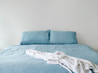 Fototapeta na wymiar Bathrobe On Blue Bed