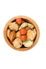 Green red and orange oriental snack mix in a bowl isolated over white