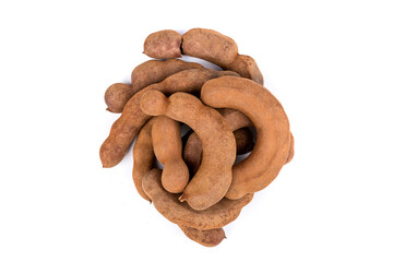 Pile dried brown tamarind pods isolated over white top down view