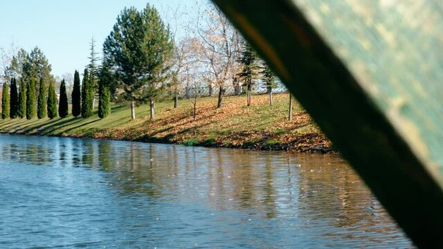 Landscape riverside in autumn. People walking along riverside. Smooth dolly motion 4K.