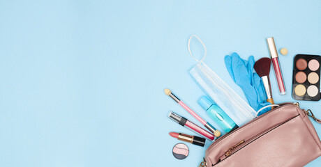 womens handbag with cosmetics and medical mask sanitizer, covid-19, flat lay