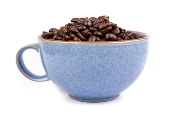 Blue ceramic cup filled with brown roasted coffee beans isolated over white side view