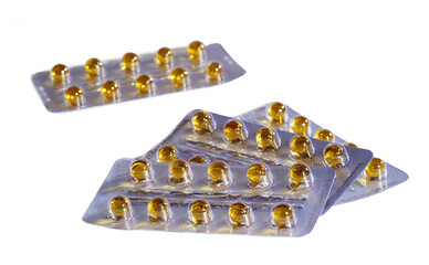 Capsules with yellow medicine on white background, isolated