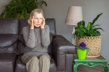 Human emotions, fear, irritation. Woman on sofa with headache.