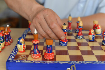 Board game of chess during self-isolation, close-up of bright matryoshka figures