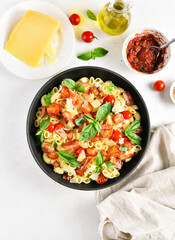 Tomato and bacon pasta with parmesan cheese and basil leaves