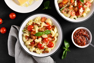 Pasta with bacon, tomato, parmesan cheese and basil leaves