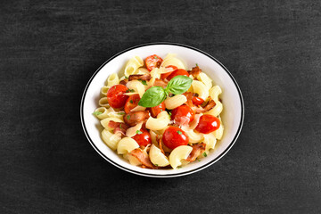 Pasta with bacon, tomato, parmesan cheese and basil leaves