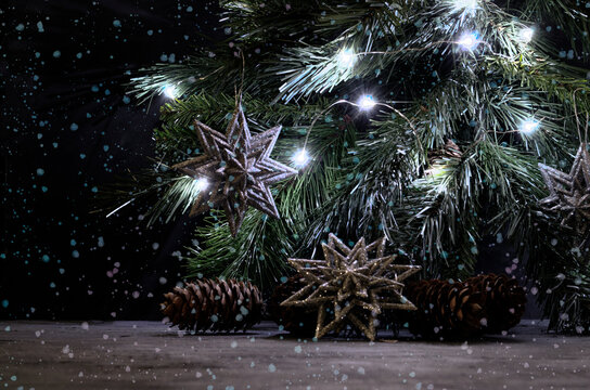 Silver snowflakes, pines and lighting garland on the spruce branch. Falling snow. Christmas still life in vintage style. Gray, black and silver colors. - Powered by Adobe