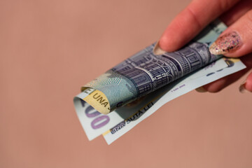 Woman hand giving money like bribe or tips isolated on white background. LEI currency banknotes...