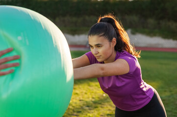 young woman doing exercises with a fitball