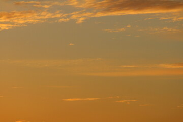 Sun below the horizon and clouds in the fiery dramatic orange sky at sunset or dawn backlit by the sun. Place for text and design