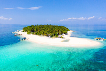 Island with a tropical beach and turquoise lagoons. Tropical island on a coral reef, top view.