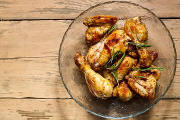 Marinated baked chicken drumsticks and wings in a plate.