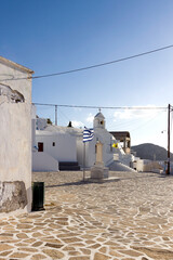 Anafi island, the cobbled square in Chora village,  traditional white building in cycladic style -...