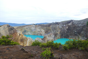photo picture of a beautiful amazing delightful volcanic multicolor lake in the crater of a volcano Lake Kelimutu National Park Island of Flores against the backdrop of a wonderful skyline.