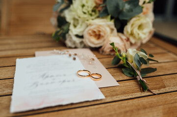 Wedding invitation letter for newlywed guests. The rings and the bridal bouquet lie side by side