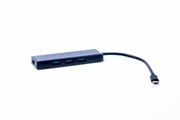 The black color of the multi USB type-c hub converter to the laptop. Isolated on a white background