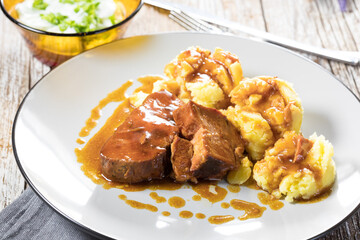 Braised pork neck in own sauce served with boiled potatoes.