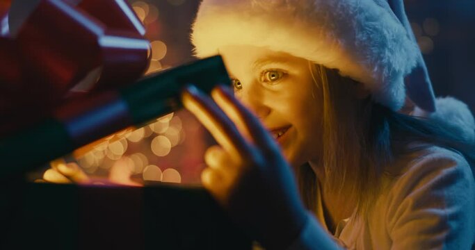 Happy girl opening magic Christmas present