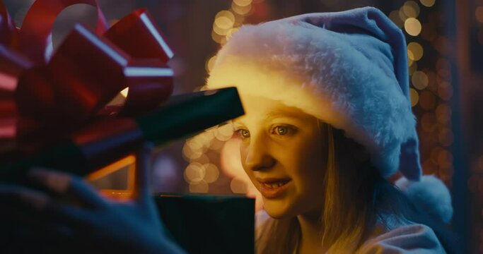 Happy girl opening magic Christmas present