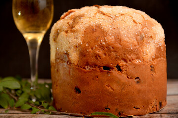 panettone italiano dolce tradizionale per la festa del natale con bicchiere di vino spumante su sfondo nero