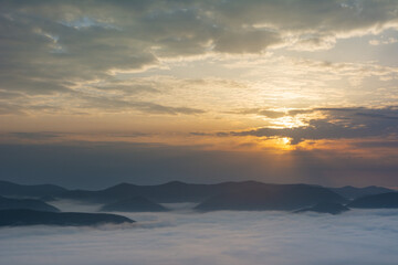 Beautiful sunrise in the Carpathian mountains with fog and dramatic sky