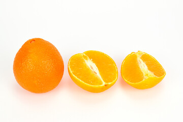 One unpeeled tangerine next to another cut in half, isolated on white background.