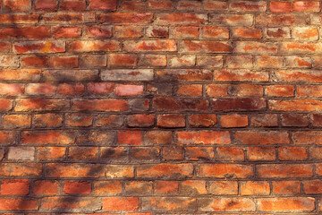 old red brick textured wall in the city with tree shadows in the daytime, textured background, backdrop