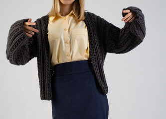 a girl with blond hair in a voluminous knitted sweater of graphite color