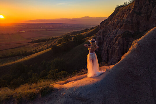 Beautiful boho chic woman on the hill enjoying an amazing sunset with gratitude