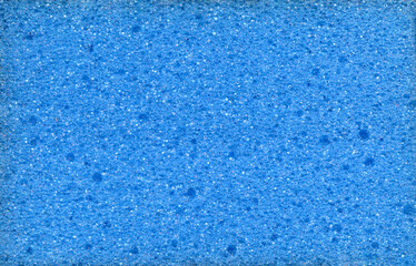 Fototapeta na wymiar Texture of blue dishwashing sponge. Abstract blue background.