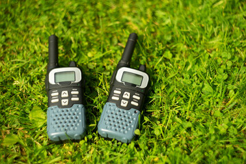 Two walkie-talkies for searching on green grass
