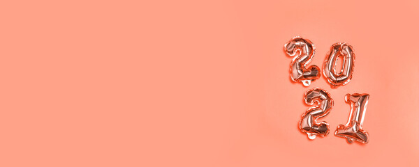 2021 gold foil balloon flying in the air on salmon background. Concept design for christmas and new year decoration banner