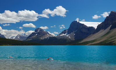 Swimmers in the icy turquoise water of Bow Lake