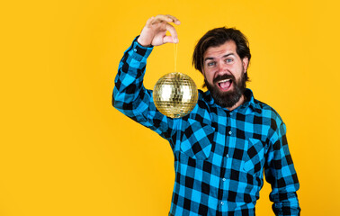 casual man holding shining disco ball. funny and joyful man having fun on party. time for fun. bearded hipster ready to celebrate the holiday. holiday decor concept. copy space