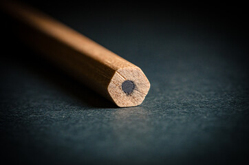 A simple pencil is on the table, macro, low key.