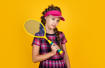 full of energy. happy childhood. kid in cap hold racket. child with racquet. teen girl do sport training. dedicated to fitness. tennis or badminton player. healthy and active lifestyle. Sport success
