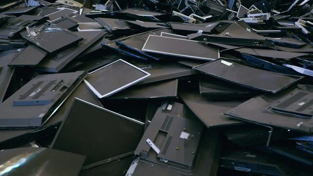 Dump of old monitors, LCD panels and flat-screen TVs. Recycling of electronic waste and plastic scrap. A huge pile of old displays.