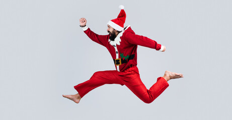 Fototapeta na wymiar new year fun. santa ctlaus in hat hurry up to xmas shopping sales. running bearded man in christmas costume. concept of freedom. happy male has funny look. winter holiday party