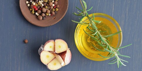 Peppers, olive oil and garlic on a wooden background.