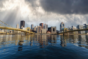 Downtown urban waterfront and bridges with stormy sky in Pittsburgh Pennsylvania.