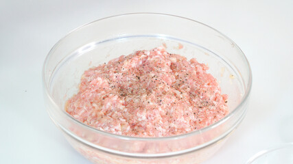 ガラスボウルに入れた塩胡椒を振った牛挽肉