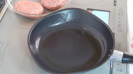 油を敷いた鉄のフライパンとハンバーグの種