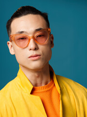 Fototapeta premium Fashionable men with glasses Asian appearance portrait Blue background