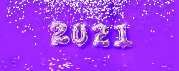 New year 2021 celebration. Gold foil balloons numeral and silver glittering confetti on lilac and purple background