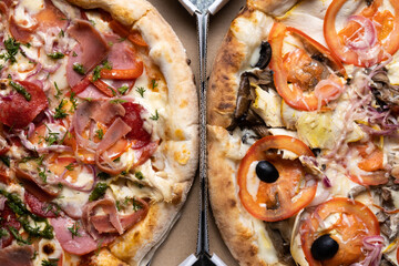 Two different pizzas in a box top view.